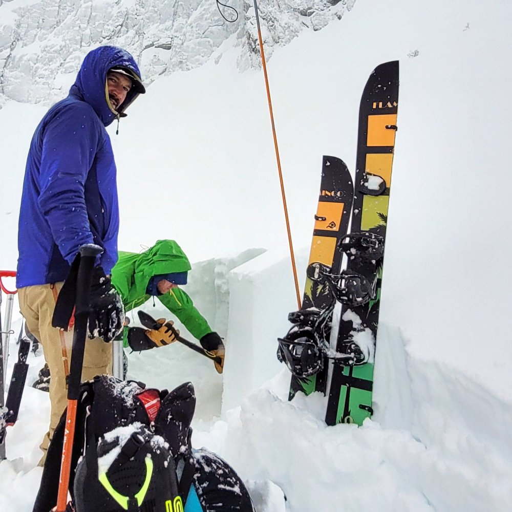 Digging a pit in the backcountry before ascending up a mountain in the Rockies 