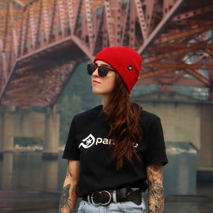 The Paradise Skis branded t-shirt in black. A lady wearing the Paradise Skis Inc black branded T-shirt with logo and the Paradise Lumberjack Red toque.
