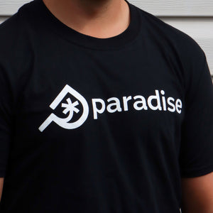 The Paradise Skis branded t-shirt in black. A man wearing the Paradise Skis Inc black branded T-shirt with logo